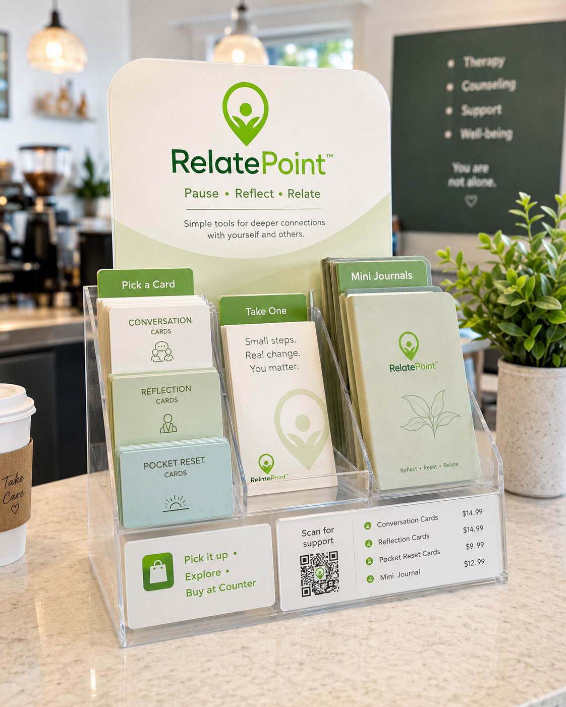 RelatePoint countertop display holding conversation cards, reflection cards, pocket reset cards and mini journals on a café counter